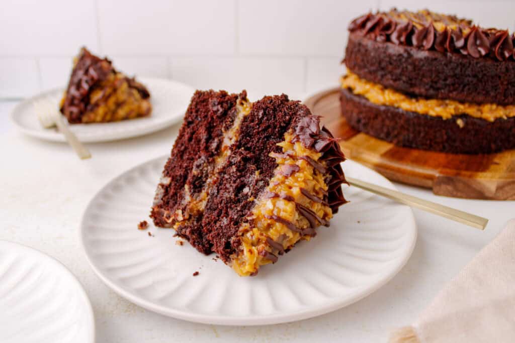 Slice of German Chocolate Cake with coconut pecan filling and chocolate ganache.