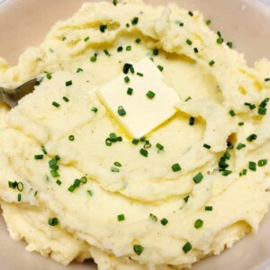 Sour Cream and Chives mashed Potatoes in a white bowl.