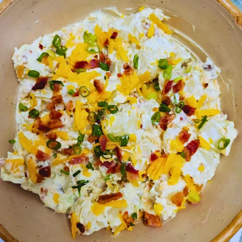 Creamy Ranch Potato Salad with bacon, shredded cheese and green onions.