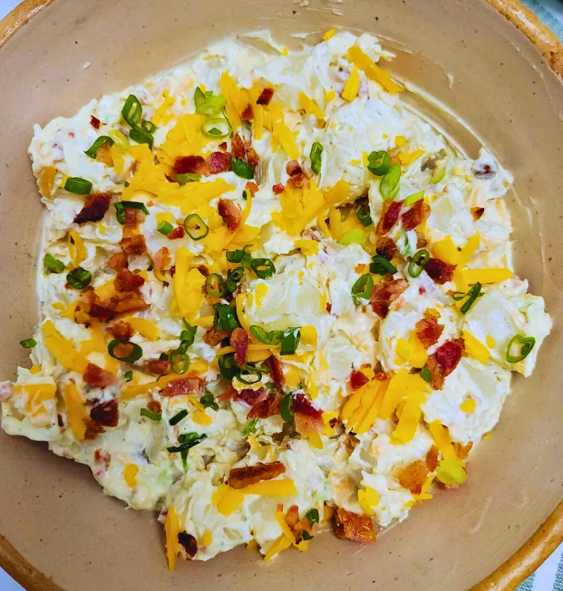 Creamy Ranch Potato Salad with bacon, shredded cheese and green onions.